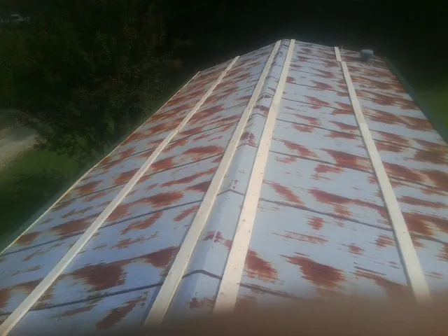 Rusted metal roof panels with new wood purlins before replacement — Storm Damage Roof Repair in New Paris by Roofing Brothers